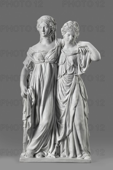 Two princesses, the so-called Prinzessinnengruppe, Koenigliche Porzellan Manufaktur KPM ; Berlin ; 1763-1918 manufacturer, Schadow, Johann Gottfried 1764-1850 sculptor, Schadow, Gottfried Johann sculptor ; 1764-1850, Luise von Mecklenburg-Strelitz 1776-1810, Friedrich von Mecklenburg-Strelitz 1778-1841, double portraits, portraits. On a flat rectangular base, two young women, arms around each other in long, antique-looking dresses made of thin fabric, draped under the bust Luiza, in sandals, with curling, parted mid-length hair. Luiza puts her arm around her sister, resting her hand on her left shoulder; with her right, lowered hand, she supports the folds of her dress. Fryderyka embraces her sister from behind around the waist, her left hand grasping her sister's arm, which is resting on her shoulder. Ca. 1795–1796, Berlin, Germany. Sculpture; height 55.0 cm, width 35 cm, depth 19.5 cm., A white marble sculpture of two draped female figures standing side by side against a gray backgro...
