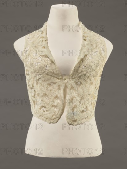 Bodice, lace, provenance, bodice; women's clothing; fashion. Pattern of rosettes connected by large spiders and heads; pattern of stylized floral motifs. 19th century, France. Clothing accessory. Height 36 cm; circumference 63 cm., A garment displayed on a mannequin torso features a sleeveless, open-front design made of delicate lace with floral and circular motifs; the lace appears in pale cream and off-white tones with subtle variations in shading, and the mannequin is an ivory-white color set against a muted gray background.