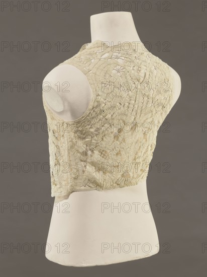 Bodice, lace; bodices; women's clothing; fashion. Pattern of rosettes connected by large spiders and heads; stylized floral motifs. 19th century, France. Clothing accessory. Height 36 cm; circumference 63 cm., A mannequin torso in off-white displays the back of a sleeveless, lace vest in a pale cream color with intricate floral and circular openwork patterns; the vest shows textured stitching and delicate scalloped edges, and the background is a smooth medium gray.