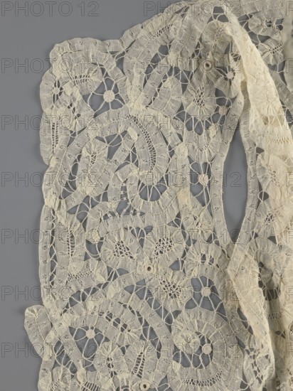 Bodice, lace, provenance unknown, bodices, women's clothing, fashion. Pattern of rosettes connected by large spiders and heads; pattern of stylized floral motifs. 19th century, France. Clothing accessory. Height 36 cm, circumference 63 cm., A delicate piece of lacework displayed against a gray background, showing an openwork pattern of interconnected floral and spiral motifs with a scalloped edge, rendered in an off-white or cream color with subtle variations in tone; the lace has fine netted areas and thicker embroidered bands creating textured loops and circular centers, and a loose, folded strip of the same material drapes along one side, all photographed flat so the intricate woven details and tiny gaps in the fabric are clearly visible.