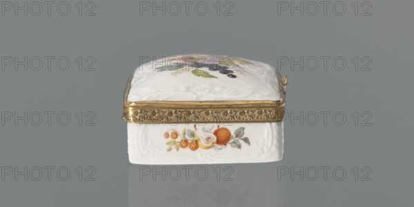 Snuffbox tin, Koenigliche Porzellan Manufaktur KPM; Berlin; 1763–1918. Snuffbox in the form of a rectangular box with a slightly arched lid, framed in gilded bronze, with a plant ornament around the outer edge of the lid and a lock, on hinges. Around the edge of the lid and the side walls of the tin there is a relief with rocaille and floral motifs. On the lid, the bottom of the base and each of the side walls are painted with colorful fruit and floral compositions including blackcurrant, fig, mirabelle plum or redcurrant, and plums. Inside the lid is a painted composition of a bouquet of flowers in a cup-shaped brown vase on a stone tabletop with fruit and a sprig of raspberry flowers; on the edge of the tabletop a small bird sparrow? nibbles a leaf, above two butterflies flying. Ca. 1765–1770. Germany, Berlin. Porcelain haberdashery snuffbox. Height 3.2 cm; width 8.3 cm; depth 6 cm., A small rectangular decorative box sits centered against a gray background, with a white porcelain bo...