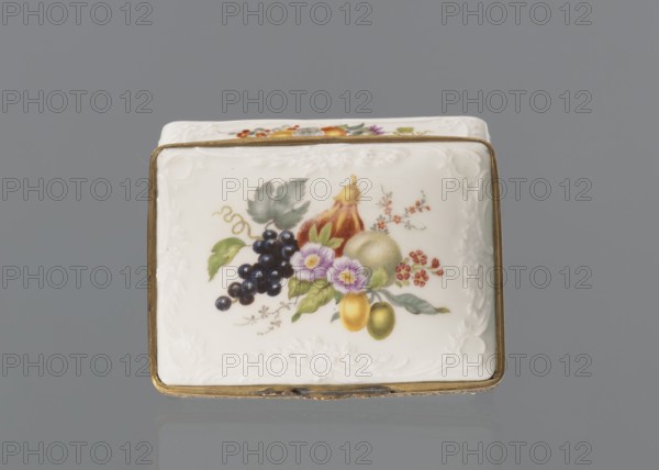 Snuffbox tin, Koenigliche Porzellan Manufaktur, ca. 1765–1770, Berlin, Germany. Snuffbox in the form of a rectangular box with a slightly arched lid, framed in gilded bronze, with a plant ornament around the outer edge of the lid and a lock on hinges. Around the edge of the lid and the side walls is a relief with rocaille and floral motifs. On the lid, the base of the interior, and each side wall are colorful fruit and floral compositions including blackcurrant, fig, mirabelle plum or redcurrant, and plums. Inside the lid is a painted composition of a bouquet of flowers in a cup-shaped brown vase on a stone tabletop with fruit and a sprig of raspberry flowers; on the edge of the tabletop a small bird sparrow? nibbles a leaf, and two butterflies fly above. Porcelain haberdashery snuffbox. Height 3.2 cm; width 8.3 cm; depth 6 cm., A rectangular white porcelain box with a gilded metal rim sits against a gray background, the top surface decorated with a painted still-life of fruit and flow...