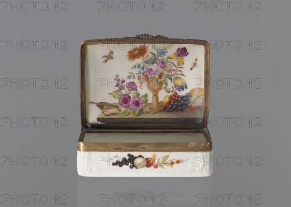 Snuffbox tin, Koenigliche Porzellan Manufaktur KPM; Berlin; 1763-1918. Snuffbox in the form of a rectangular box with a slightly arched lid, framed in gilded bronze, with a plant ornament around the outer edge of the lid and a lock, on hinges. Around the edge of the lid and the side walls of the tin there is a relief with rocaille and floral motifs. On the lid, the bottom of the base and each of the side walls are painted with colorful fruit and floral compositions including blackcurrant, fig, mirabelle plum or redcurrant and plums. On the inside of the lid is a painted composition of a bouquet of flowers in a cup-shaped brown vase on a stone tabletop with fruit and a sprig of raspberry flowers; on the edge of the tabletop a small bird sparrow? nibbling a leaf, above two butterflies flying. Ca. 1765–1770. Germany, Berlin. Porcelain haberdashery snuffbox. Height 3.2 cm; width 8.3 cm; depth 6 cm., A small rectangular box with an open lid sits against a gray background; the interior of th...