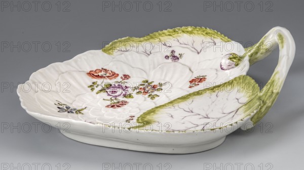 Leaf plate, Kaiserliche Porzellanmanufaktur in Wien 1744–1864. Leaf-shaped dessert plate with relief-modeled surface: large white flower peony? and two green underpainted leaves; plastic shoot handle set on the edge with a flower bud; trimmed bases on the reverse of the collar. On the surface, the flower relief bears a colorfully painted loose floral arrangement and five sprigs with flowers; leaves and stem handle painted green with purple veining. Ca. 1760, Vienna, Austria. Plate: height 6.8 cm; width 24.5 cm; depth 22.5 cm., A white ceramic dish shaped like a large leaf with a curved handle is shown against a gray background; the dish has scalloped edges and raised vein-like ridges, decorated with painted floral motifs in colors including green, purple, red, pink, and orange, with additional small floral accents in blue and yellow; the rim and parts of the interior have green shading and delicate branch-like lines in a muted purple, and the handle has green brushwork blending into th...