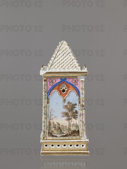 Night Lamp, Popow, Alexander porcelain manufacturer; 1806–1872 author, lamps, landscapes with architecture. Neo-Gothic, plant motifs. Lamp composed of three parts: base, lamp, and cover. Base with a horizontal row of holes on each side creating a decorative trail. Lamp in the form of a cube, in the neo-Gothic style; arcades in the shape of tracery painted with colorful landscapes: two with motifs of flowering bushes primrose and jasmine, floral motifs against the background of a landscape, two landscapes with an architectural motif. 19th century, Russia, Gorbunovo. Lamp, height 32.2 cm, width 13 cm., A tall decorative object resembling a small tower with a pointed, tiled roof in white with gold accents sits against a gray background; below the roof, the tower has painted panels framed by a mottled pastel border in pink, green, and white, with a central arched panel featuring blue, red, and gold ornamental motifs above a painted landscape scene showing trees, water, and distant building...