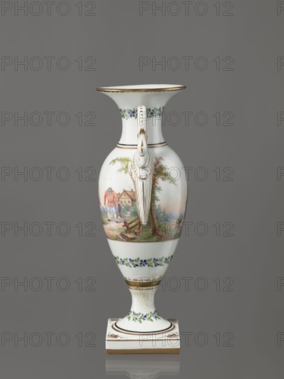 Amphora vase, Imperial Porcelain Factory in St. Petersburg 1744–1917. Genre miniatures; genre scenes in landscapes; rural landscapes. Amphora vase with an ovoid body and a slender neck that flares upward. Slender, tall foot on a square plinth. Two handles in the form of swans. Neck, foot, and lower body decorated with a colorful trail of small flowers. On the belly, two miniatures depicting rural landscape scenes: a woman doing laundry, leaning over a tub on a low table while a man with a dog watches; and two men with their arms around each other, one holding a bottle, a third leaning forward in the background. Early 19th century, Russia, St. Petersburg. Figurine/vase. Height 26.5 cm; width 11.0 cm; depth 9.0 cm., A tall porcelain vase with a flared rim and a single curved handle is shown against a gray background; the vase is primarily white with painted floral garlands in blue and green near the rim and base, gold accents along the rim, handle, and pedestal, and a painted pastoral sc...