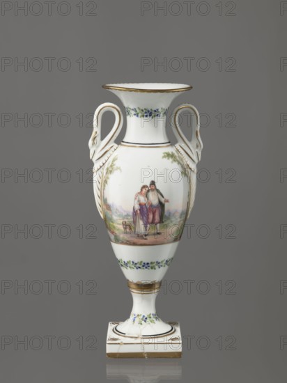 Amphora vase, Imperial Porcelain Factory in St. Petersburg 1744–1917. Amphora vase with an ovoid belly, slender neck flaring at the top, high foot on a square plinth. Two handles in the form of swans. Colorfully painted: trails of small flowers on the foot, neck, and lower part of the belly. On the belly, two miniatures depicting genre scenes in a rural landscape: a woman with a pole water carrier siudy, koromyslo and a couple with a dog. Base cracked and glued. Early 19th century, St. Petersburg, Russia. Figurine/vase. Height 26.5 cm, width 11.0 cm, depth 9.0 cm., A white porcelain vase with a flared rim and a pedestal base, decorated with gold trim and bands of small blue and green floral motifs, featuring a painted pastoral scene of a couple standing together on the body with a small animal nearby, and ornate curved handles shaped like stylized swans attached to the shoulders; colors visible include white, gold, blue, green, brown, purple, and muted flesh tones, set against a neutra...