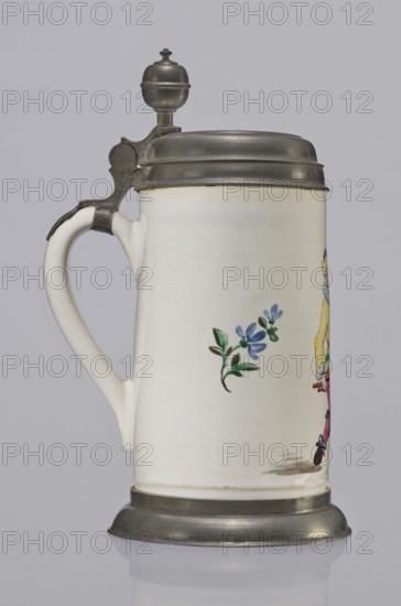 Tin-mounted tankard, Prószków Slaski faience factory 1763–1853. White cylindrical tankard with a pewter mount. On the front is a depiction of an obese musician playing a double bass, shown in vigorous movement; the musician wears a yellow jacket, purple pantaloons, and a lilac hat with a yellow brim. Floral sprigs on the sides. Tin cover engraved CGH/1811. Late 18th century. Silesia Province of Silesia, 1742–1918. Vessel. Height 24.0 cm; width 15.0 cm; depth 9.5 cm., A ceramic stein with a white body and a curved handle, topped with a metal hinged lid and finial and with a metal base, showing a small painted blue flower with green leaves on its side and part of a colorful figurative decoration at the edge; visible colors include white, gray, blue, green, yellow, pink, black, and metallic gray.