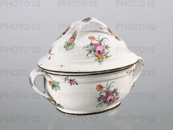Vase with lid, Prószków Slaski faience factory 1763–1853; egg-shaped soup tureen with lid in the form of a flattened ellipsoid/hemisphere. Handles of the vase and lid are in the form of two crossed ribbons. Decorated with small painted floral projections and large bouquets of multicolored flowers; on both sides of the vase and lid are bouquets with a pink rose. Handles adorned with vermilion daisies with large green leaves. Rim of the vase and cover painted brown. Floral decorations, roses. Circa 1785. Silesia Province of Silesia. Vessel. Height 25.5 cm; length 35.5 cm., A white ceramic covered bowl with a lid and two handles sits against a pale gray background, decorated with painted floral motifs in pink, green, orange, yellow, and a bit of blue, with brownish brush accents on the handles, rim, and base; the lid has a curved double-arched handle and matching floral decorations, and the bowl shows several clusters of flowers and leaves around its sides.