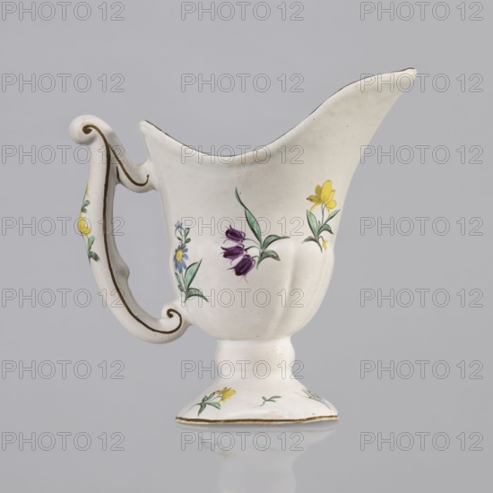 Nalewka, Prószków Slaski faience factory; 1763–1853, maker/manufacturer inscriptions, floral decorations, locking, carnations flowers, repossession, helmet-shaped nalewka with locking and fluted surface. Bowl base and vaulted foot modeled with four leaves. T-shaped handle. Colorful decoration: bouquet with a large purple carnation with three buds and three small yellow flowers. Small projections of flowers and leaves. Brown borders along the handle, edge of the bowl, and foot. Dated 1770–1783. Region: Silesia, Province of Silesia. Place: Prószków Slaski. Vessel; height 19.0 cm, width 19.0 cm, depth 9.5 cm., A white ceramic pitcher with a curved handle and flared spout sits against a pale gray background, decorated with painted floral motifs in yellow, purple, blue, and green, with a thin gold-colored trim along the rim, handle, and base; the handle has a scroll-like shape with painted accents, the body has a gently bulbous shape narrowing to a pedestal foot, and the surface shows small...