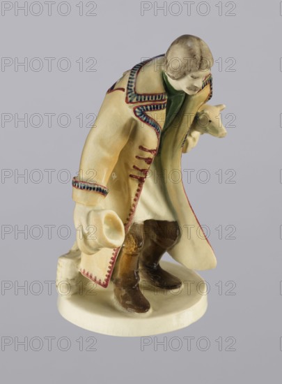 Peasant with Piglet, First Galician Factory of Artistic Faience and Terracotta Pacyków; 1912–1939, Popiel, Antoni 1865–1910, sculptor. Figurine of a man peasant in a Hutsul russet coat on a circular base. The peasant, with straight-cut hair and a period mustache, stands slightly bowed, holding a hat in his right hand and a piglet under his left arm. At the back on the base is a woven basket. Warm tones: light ochre russet coat with brown-purple trim; underneath a green vest, dark trousers, and brown shoes. Circa 1910, Pacyków; terracotta/faience figurine; 14.5 cm high, 8.0 cm wide, 5.5 cm deep., A ceramic figurine of a person wearing a long coat and holding a hat, standing on a round base; the coat is primarily cream with decorative trim in blue and red and an inner lining showing green, the person has brown hair and a mustache, a pale face and hands, and is holding a small animal head that is pale in color; the boots and lower garments are brown, the base is off-white, and the backgro...