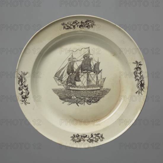 Plate, Herculaneum Factory 1793–1841. Shallow plate with a narrow collar. Printed decoration: on the collar four double interwoven floral sprigs; in the mirror a miniature of a sailing ship under full sail on the waves. Miniatures with sailing ships, floral decorations, print. Late 18th century, Liverpool, England. Earthenware plate, height 2.7 cm, diameter 25.0 cm. Unknown provenance., A round ceramic plate with an off-white, cream surface and a glossy finish, showing a detailed dark brown illustration of a sailing ship with multiple masts and rigging positioned in the center, surrounded by a textured depiction of water and a few small objects near the hull; the rim features several decorative dark brown floral motifs spaced around it, and there are subtle hairline cracks and small discoloration spots in shades of beige and light brown on the plate surface, all set against a plain gray background.