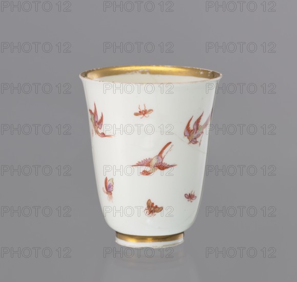 Teapot, Koenigliche Porzellain Fabrique, Meissen 1710–1763. Maker: Meissen. Teapot, slender, tall, chalice-shaped, without handle; height 7.1 cm, diameter 6.3 cm. Porcelain teapot c. 1730, Saxony. Decorated with a miniature landscape within a Rococo cartouche, gilded lace in red and yellow with metallic-violet fields Perlmutterlüster. Back surface painted with birds and insects; overall painted miniatures and cartouches; function: vessel., A white porcelain cup with a flared rim and a narrow foot is shown against a gray background; the rim and foot have gold-colored bands, and the cup is decorated with small painted birds and insects in shades of red, orange, purple, green, and brown, with visible fine outlining and delicate brushwork on the white surface.