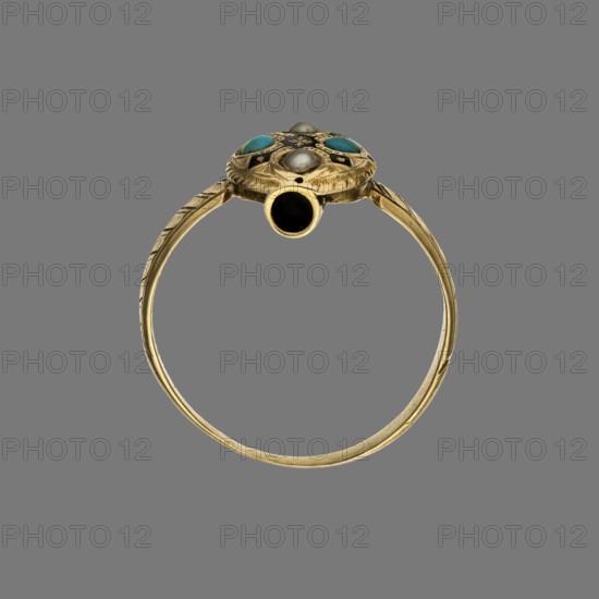 Ring, Doreau, Romain fl. 1848–1863, jeweler. Oval gold ring with a band that widens slightly and has diagonal notches. Divided by strips of black enamel into four fields, each containing two alternating turquoises and two half-pearls. Along the ring's underside, a tube with an oculus containing nine visible portrait photographs from the 1850s. Paris, France. Jewelry. Height 1.2 cm; width 2 cm; depth 2.2 cm., A close-up image of a circular metal ring displayed against a solid gray background, showing a thin gold band with engraved linear patterns along its sides and a decorative bezel at the top; the bezel has a domed central element and a surrounding design that includes a few small round cabochon stones in turquoise blue and several pale silvery-gray beads, with areas of darker black detailing within the decorative top.