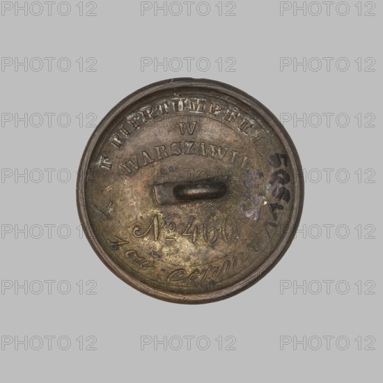 Round uniform button, slightly convex, shank broken off. Obverse inscribed D:S:/P:E. Reverse in rim reads maker's name F. BIERTUMPFEL / in WARSAW / No. 460 and in Cyrillic 1oj sort. Maker: Biertümpfel, Frederick fl. 1832–1870. Late 19th century, Warsaw, Poland. Clothing accessory. Diameter 2.5 cm. Monograms. Provenance unknown., A round metallic object with a raised rim and a central loop, showing a worn, aged surface in shades of brown, bronze, dark gray, and hints of greenish patina, with areas of darker discoloration and a few spots of darker bluish-black markings; the background is a uniform light gray.