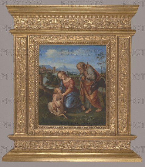 Holy Family with a Lamb, Penni, Giovanni Francesco ca. 1496–ca. 1528 painter; Raphael 1483–1520 author copy after; religious painting depicting the Holy Family Mary, Jesus Christ, Saint Joseph with a lamb, scenes against a landscape background; Italian painting, Italian landscapes; after 1507; painting; height 43.5 cm, width 38 cm; with frame: height 68 cm, width 59.5 cm, thickness 6.5 cm., A painted scene set within an ornate gold frame shows a woman in a red and blue dress seated on grass beside a small child who is nude and seated on a resting sheep, with an older bearded man wearing a cloak and carrying a staff leaning toward them; the background contains a landscape with green trees, distant hills and mountains under a blue sky with clouds, and a few buildings along a river.