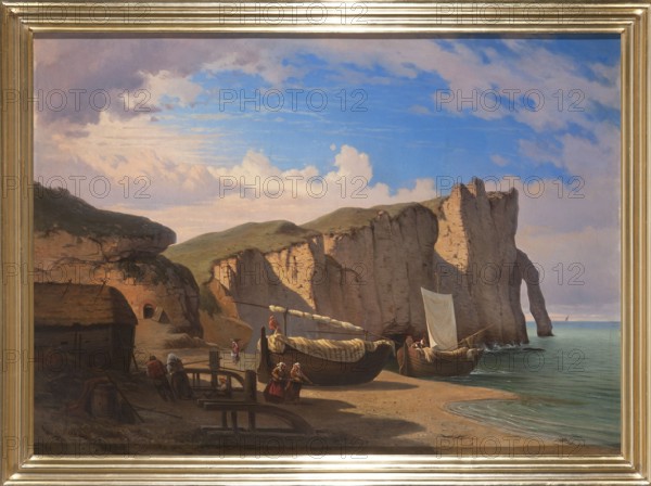 View of Cap d'Entifer in Étretat, Normandy, Zamett, Albert 1821–1877, painter; 1850; painting; seascape/landscape with staffage depicting barges, rocks, Cap d'Antifer Normandy, France; height 77 cm, width 105 cm., A coastal scene showing a sandy shore with a group of wooden boats pulled up on the beach and a few boats at the water’s edge, several people near the boats wearing muted clothing in shades of red, brown, and white, and a small thatched structure to the left. Towering chalk cliffs rise from the shoreline toward the right with grassy tops and a natural arch visible near the water, casting shadows across the beach. The sea is calm with gentle waves lapping the sand and a horizon line under a sky filled with blue tones, white and pale pink clouds, and areas of soft purple and gray. The foreground contains wooden beams and equipment, a barrel, and scattered ropes in darker brown tones. The whole scene is framed by a gilt rectangular frame.