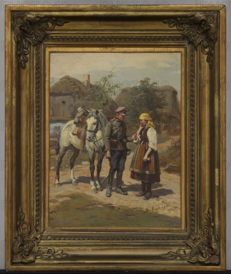 Soldier and a Peasant Girl, Stanislaw Bagienski 1876–1948, painter; 1925; oil painting; 45.5 × 35.5 cm, A framed painting shows a rural outdoor scene with a group of figures and a horse in front of thatched buildings and trees. The frame is ornate and golden with decorative corners and a multilayered inner border. Inside the frame, a white horse with a brown saddle stands beside a man in a dark uniform with a peaked cap, and a woman wearing a dress with an apron and a yellow headscarf; the man and woman face each other. The ground is earthy with tones of brown and green, and the background sky is pale blue with muted clouds. Visible colors include gold on the frame, white and brown on the horse, dark gray and green on the uniform, yellow on the headscarf, brown and red tones in the woman’s skirt, and green and brown in the foliage and thatch.