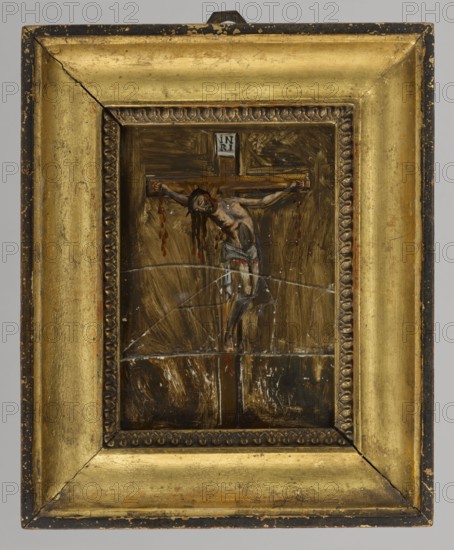 Christ crucified, unknown Polish painter, 19th century, painting, height 17 cm, width 13 cm, A painted depiction of a crucifixion scene set within a decorative rectangular gold frame, showing a central wooden cross with a human figure hanging from it wearing a cloth around the waist; the figure has dark hair and visible red markings suggesting dripping, and the limbs are outstretched and attached to the horizontal beam. The background inside the frame is a mix of dark brown and ochre brushwork with lighter streaks radiating outward, and there are visible lighter scratch-like marks across the painted surface. The frame itself is gold with a darker inner border that has a repeating carved pattern, and the outer edges show areas of darker wear and small spots where the gold finish is worn to darker tones.