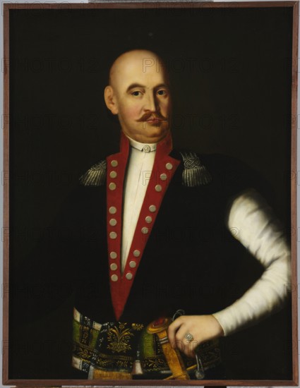 Portrait of Antoni Kars Sariusz Bonin Slowianowski in Slowianów, captain of the armored banner, unknown Polish painter; portraits, nobility, military men, Sarmatian portrait. Shot below the waist, frontally, shaved head tilted to the right, left hand resting on the belt; wearing a white zupan and a uniform kontusz of a captain of an armored banner from 1746–1775 — navy blue with crimson lapels, shoulder boards and silver buttons, tied at the waist with a patterned silver-plated belt, with a saber at the left side. 18th/19th century, Poland, painting., A framed portrait of a bald man with a mustache and neutral expression wearing a dark coat with a red trim and metallic buttons and shoulder epaulettes, a white shirt visible under the coat, and a patterned sash around his waist; his right arm is bent and his hand rests on a sword hilt, the hand showing a ring. The background is dark. Visible colors include black, red, white, gold, green, brown, and flesh tones.