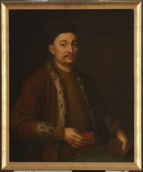 Portrait of Prince Jeremi Wisniowiecki, unknown Polish painter. Figure shown from the hips, turned 3/4 to the right; wearing a yellow zupan fastened with a row of small buttons and a red delia trimmed with lynx fur. The right hand, with a signet ring, rests on the belt; the left hand holds a book. 17th century, Poland. Oil painting, height 86.5 cm, width 71.5 cm. Includes iconography of Jeremi Wisniowiecki and the Korybut coat of arms., A painted portrait of a man shown from the waist up, wearing a dark brown coat with a fur-trimmed collar and cuffs and a mustard-colored garment underneath, seated against a dark brown background. He has short dark hair, a mustache, and a neutral facial expression, with light skin tones and subtle rosy cheeks. One hand rests near his midsection holding a small red cloth, while the other hand holds a rectangular brown object. The image includes a gold-colored frame surrounding the painting. Colors visible include dark brown, brown, mustard, tan, cream, r...