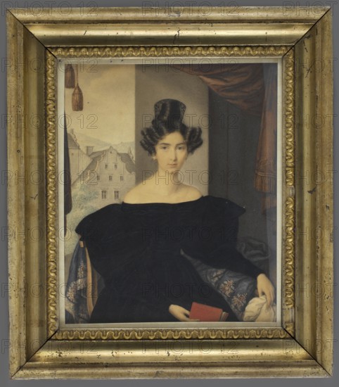 Henriette Clementine Sophie Amalie Ernestine 1805–1849, countess von Reichenbach-Goschütz Reichenbach; priest Reuß zu Köstritz Kowary. Miniature portrait, 1830. Full-face seated female portrait in interior with armchair and curtains; dress with crinoline, scarf, bun hairstyle. Includes books, architecture and city views/streets in background. Biedermeier style; height 23.0 cm, width 19.2 cm., A framed portrait of a seated woman wearing a dark off-the-shoulder dress and an elaborate dark hairstyle, holding a small red book in one hand and a light cloth in the other; the woman has a pale complexion and a neutral facial expression. The background shows a window or opening with a view of a light-colored building and rooftops on one side and a dark draped curtain with tassels on the other. The portrait is set in an ornate gold frame with a decorative inner border and visible wear marks, showing colors including black, dark brown, gold, pale beige, light gray, red, and muted blue.