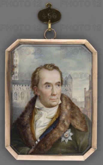 Portrait of Mayor von Schon 1773–1856, painted by Christian Horneman 1765–1844. Miniature height 7.6 cm, width 5.6 cm, 1840. Three-quarter bust, turned right: blond hair, blue eyes; wearing a white shirt and tie, yellow-gold waistcoat, sapphire-blue frock coat, and an olive coat with beige-brown fur. Order star on the left breast Order of the Black Eagle. Subjects: rulers/officials, men elder, portraits to the waist. Includes cityscape background with gray-blue and gray-brown urban architecture cathedral and town hall building? and a blue-white sky. Smooth gilt-bronze border. Denmark., A small framed portrait of a man shown from the chest up wearing a fur-lined coat and a light scarf around his neck, with light brown hair and blue eyes and a contemplative expression; the background shows architectural structures and a cloudy sky. The frame is metallic and octagonal with a linked hanging loop and a small attached oval plate above it. Visible colors include gray, brown, tan, beige, white...