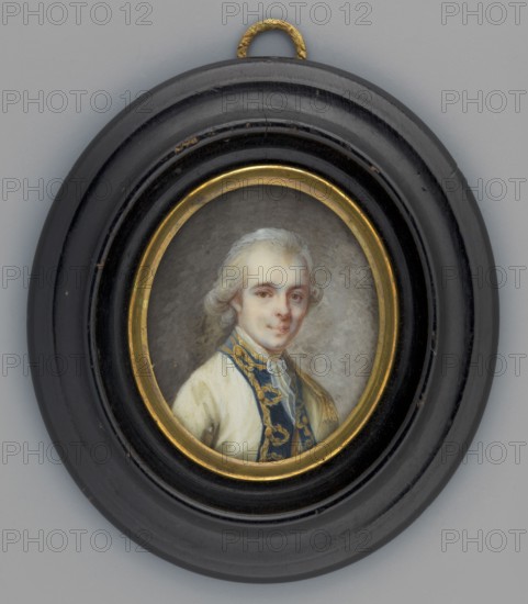 Portrait of a young man in a cream tailcoat from the family of the Duke de Cosse-Brissac ?Hyacinthe Hugues Timoleon, unknown artist; aristocracy, male three-quarter portrait; Polish miniature. Bust three-quarter right. White wig tied with a bow at the back of the head; white ears and cravat; cream tailcoat with navy blue lapels embroidered with gold. Background uneven brown-grey, brightened on the right. Oval gilded bronze border; in an oval wooden frame, recessed and profiled, polished to look like mahogany. 1790, France. Miniature; height 4.5 cm, width 3.7 cm., A small oval portrait set in a round black frame with a gold inner rim and a small textured gold hanging loop at the top shows a light-skinned person with powdered white hair styled back, wearing a cream-colored garment and a dark blue garment with gold embroidered trim; the background behind the figure is a muted gray.