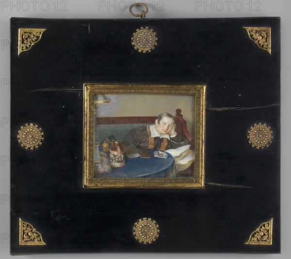 Anna Nikaunovna née Schenschine at the table, perhaps the daughter of the director of the Warsaw–Vienna Railway, Major-General Schenschine Kurjer Warszawski, 1855, No. 325, interiors, girls, houses, children, family, books, portraits, foreign miniatures, costumes, toys, ca. 1850, Russia, miniature, height 7.6 cm, width 9.1 cm, A framed rectangular image set into a larger black panel with decorative gold corner ornaments and circular gold medallions, the central painting showing a person reclining at a round blue table covered with various objects including containers and fabric; the person has a fair complexion and dark hair, wearing a dark garment with a white collar and brown accents, resting their head on one hand while leaning on the table, with a wooden chair back visible behind them and a muted background in pale tones; visible colors include black, gold, blue, brown, white, pale flesh tones, red, and gray.