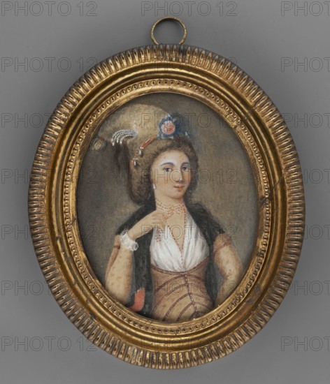 Helena Tudesca, unknown painter, portraits 3/4 right, flowers, women, headgear turban? egreta?, foreign miniatures, amateurs, 1787, miniature, height 9.8 cm, width 7.7 cm, An oval gilded frame with a textured rim surrounds a painted portrait of a woman shown from the waist up; the frame is gold with darker aged areas and a small hanging ring at the top, and the background behind the portrait is gray. The woman has brown curly hair adorned with a light-colored plume and a blue and pink floral ornament, and she wears pearl or bead earrings; her skin tone is light and her expression is neutral with slightly raised eyebrows. She is dressed in a white low-necked bodice with a fitted brown or tan corset-like garment over it and a dark shawl draped over her shoulders, and she wears a delicate necklace and bracelets that appear to be made of small beads. The painting palette includes gold, gray, brown, white, blue, pink, black, and subtle flesh tones.