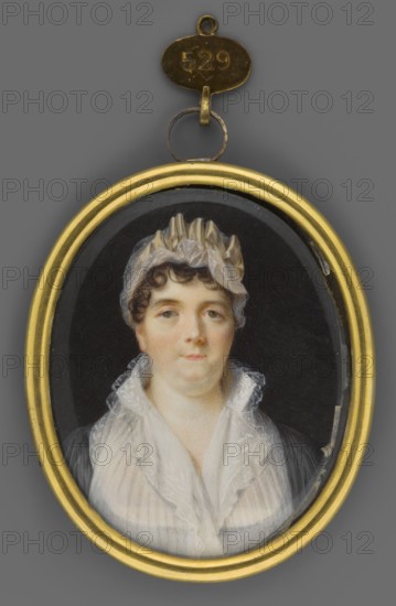 Portrait of an Elderly Woman in a White Cap, unknown artist. Subject: female portrait of an elderly woman wearing a white cap; style: miniature; date: 1820; place of origin: Germany. Medium/format: miniature, height 6.7 cm, width 5.7 cm. Keywords: women, portraits, costumes, headgear, foreign miniatures., An oval miniature portrait in a gold frame shows a woman against a dark background; she has pale skin, short dark brown curly hair partially covered by a light-colored, ruffled cap, and a neutral expression. She wears a sheer white shawl or scarf with delicate lace edging over a darker garment, and the portrait is suspended from a small metallic loop and tag above the frame. Visible colors include gold, gray, black, white, pale peach, light brown, and dark brown.