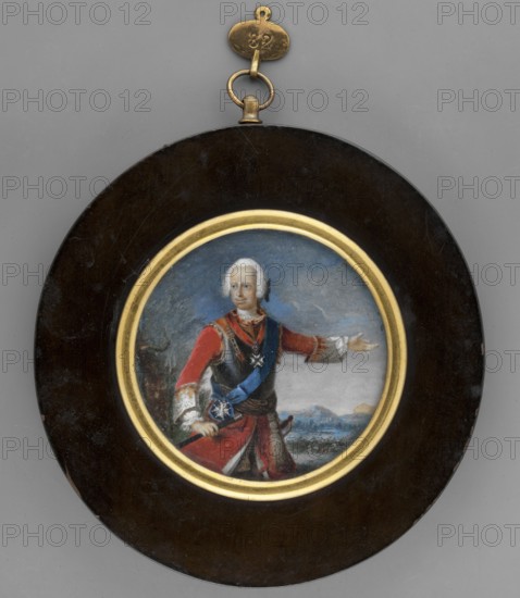 Louis VIII, Landgrave of Hesse-Darmstadt 1691–1768, unknown artist, miniature 1800, height 6.3 cm. Standing 3/4 left; red uniform, gray armor, right hand on a sabre, left hand outstretched. Wig with a pigtail; Iron Cross on the chest. Background: grey-blue with a pinkish lower sky, blue mountainous landscape, soldiers in the background, bushes on the left. Round binding with a narrow rim of gilded bronze in a thick wooden frame. Subjects: men, rulers, male portrait, soldiers in armor, battle landscape; inscriptions/notes: orders, foreign miniatures; geographic: Hesse Germany., A round framed miniature portrait hung by a small metal loop, showing a light-skinned person with white hair wearing a red coat with white cuffs and a blue sash across the torso, a dark vest or cuirass, and decorative metallic elements; the figure gestures with one arm extended and the other resting near a sheathed sword, set against a cloudy blue-gray sky and a distant landscape with water and landforms; the por...