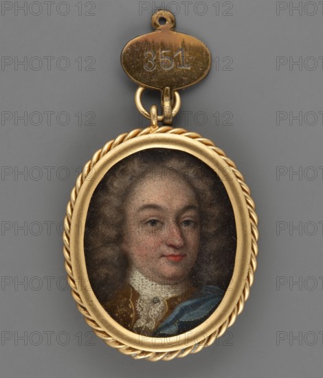 Portrait of a man in a lion-style wig, Georg von Hessen-Darmstadt 1669–1705 ?, unknown artist, men's portrait 3/4 right, aristocracy, costume tailcoat, jabot, hairstyle lion-style, jewelry brooch at the jabot, foreign miniature, 1750, miniature, height 3.4 cm, width 2.8 cm, An oval pendant with a twisted gold frame enclosing a painted portrait of a person with pale skin, flushed cheeks, light brown curly hair, and a neutral expression, wearing a white lace collar and garments with brown and blue tones; the pendant is attached by gold rings to a small oval gold tag, and the background behind the pendant is gray.
