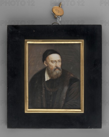 Copy of Titian's self-portrait by Thil, Wilhelmine Louise du 1782–1819, amateur painter; miniature portrait of a man, painted 1816, height 8.0 cm, width 6.4 cm., A framed portrait of a bearded man wearing a dark cap and dark clothing is centered within a rectangular black frame that has an inner gold border; the man has a pale complexion and light brown beard and hair, and his face is turned slightly to the side with a neutral expression. The painted background behind him is a mix of muted brown and gray tones. The outer frame is matte black with some scuffs and a small metal hanging fixture attached at the top, and there is a small round metal tag near the hanging hardware that is a warm brass color. Overall visible colors include black, gold, brown, gray, pale skin tones, light brown, and brass.