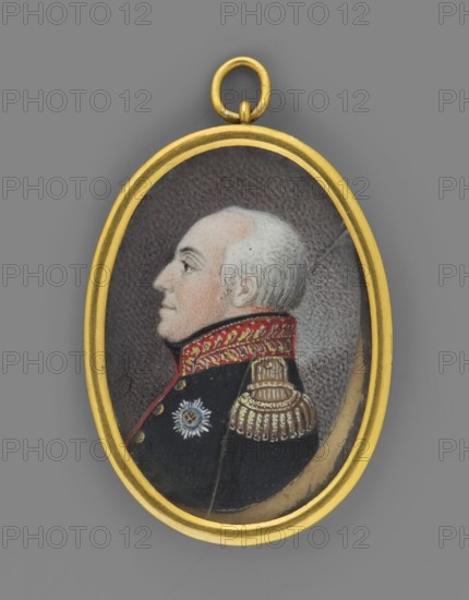 Profile portrait of Prince Alexius Friedrich Christian of Anhalt-Bernburg 1767–1834 in a Russian uniform with the star of the Order of St. Andrew; unknown artist; male portrait, soldier, profile miniature; Order of St. Andrew the Apostle of the First Calling; 1833, Germany; miniature, height 5.3 cm, width 2.7 cm, An oval pendant with a gold-colored frame contains a painted profile portrait of an older man with pale skin and white hair, shown against a dark textured background; he wears a dark uniform with a high red collar decorated with gold patterns, a gold-colored epaulette on the shoulder, and a small decorative star-shaped badge on the chest, and the pendant hangs from a round gold-colored loop.
