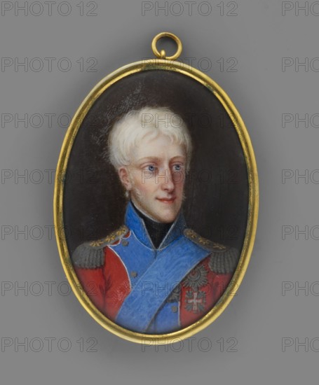 Frederick VI of Denmark 1768–1839, King of Denmark; painted by Johann Gorbitz 1782–1853. Miniature portrait 1815, height 5.3 cm, width 3.7 cm. Bust in full view, head facing right. Depicts a man in a red uniform with blue collar and rebates; wearing the star and ribbon of the Order of the Elephant and the cross of the Order of the Dannebrog. Background plain, brownish. Binding: gilded bronze. Attributions: Anna Chamiec; scientific cards Iza Wiercinska., An oval pendant with a gold frame contains a painted portrait of a young person with pale blond hair and light skin, shown from the chest up against a dark background; they wear a red coat with gray epaulets and decorative gold details, a bright blue sash across the chest, and a black high collar, and the pendant hangs from a small gold loop.