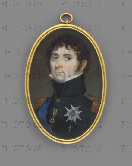 Charles XIV Bernadotte, King of Sweden 1763–1844; François Gérard 1770–1837, painter; ca. 1815; miniature portrait height 5.3 cm, width 3.5 cm; depicts the king in uniform, wearing orders including the Order of the Golden Fleece; subject: male ruler/commander/politician; foreign miniature; inscriptions/provenance notes: repossession Jelenia Góra, repossession Salzburg., An oval pendant with a gold frame containing a painted portrait of a man shown from the chest up wearing a dark uniform with a high collar and shoulder epaulets, a blue sash across his chest, a star-shaped medal and another hanging medal; the man has pale skin, dark curly hair, sideburns, and a neutral expression, and the background inside the pendant is dark while the surrounding area outside the frame is gray with the gold suspension ring visible at the top.