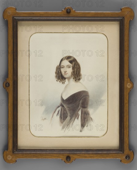 Eliza Elzbieta née Branicka 1820–1876, Zygmuntowa Krasinska, daughter of Wladyslaw and Róza née Potocka; painted by Emilio Rossi ca. fl. 1830–1850. Miniature portrait, 1840; height 20.0 cm, width 5.2 cm. Subjects/themes: aristocracy, women, female portrait. Place of origin: Krzeszowice Lesser Poland Voivodeship, Russia., A framed portrait of a young woman with pale skin and dark brown, curly shoulder-length hair, shown from the waist up and facing slightly toward the viewer; she wears an off-the-shoulder dark brown dress with lighter, flowing sleeves and a low neckline, and her expression appears neutral. The portrait is set against a light, softly shaded background in tones of pale gray and cream, and the image is matted with a beige or light tan mount that has a thin decorative border. The frame surrounding the mat is wooden with a warm brown finish and darker brown inner trim, featuring rounded decorative corners and small circular accents at a few points.