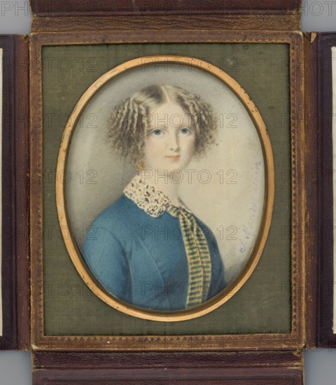 Portrait of a Young Woman in a Blue Dress, Marszalkiewicz, Stanislaw 1789–1872 painter. Bust three-quarters facing right. Blond hair parted in the middle and combed in an angled style on both sides of the head. At the neck: turn-down white lace collar and a long narrow yellow tie with horizontal green stripes falling at both ends onto a bluish dress. Background light grey, darker at the top, sandy on the right. Inscription along the right edge: S. Marszalkiewicz 1832. Miniature, 1832, Poland. Height 12.2 cm, width 9.8 cm. Binding: gilt-bronze, leather, plush; semi-convex oval gilt-bronze border in a rectangular brown leather case with embossed olive-coloured plush., An oval portrait of a young woman with pale skin and light brown curly hair set in a rectangular frame; she wears a blue dress with a patterned white collar and a vertically striped tie-like ribbon, and has light blue eyes and a neutral expression; the portrait is surrounded by a gold rim and mounted on an olive-green fabri...