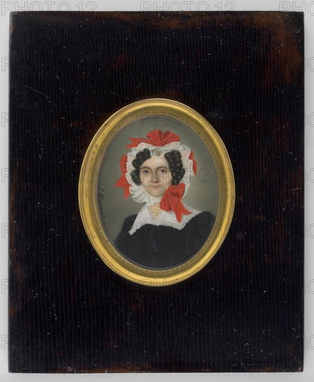 Aniela, née Czarnecka, Countess Krasicka, wife of Leon, painted by Stanislaw Marszalkiewicz 1789–1872. Miniature portrait 1838 of an elderly woman, 3/4 bust right, head almost straight. Black hair gathered in tubular curls above the forehead and around the temples and face. She wears a white ruffled headdress trimmed with large bright red bows; a la ferronnière with a jewel above the forehead; pearls around the neck; a white collar trimmed with a fine ruffle; and a black dress. Grey-greenish background. Frame: gilded bronze and wood, slightly recessed oval rim of gilded bronze with a palmette motif in a flat, black-polished slat; beveled glass. Along the left edge: S. Marszalkiewicz. Inscription on the reverse of the binding early 20th century: A/z Czarnecki/Krasicka/Mother of Witold and Miaczynska/Waclaw and Oskierczanka/and Edward and Oginska/Mal. in 1838/by S... ...kiewicz. Miniature dimensions: height 7.2 cm, width 5.7 cm., A framed oval portrait of a woman set against a dark brown...