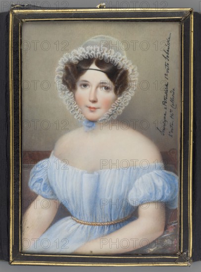 Portrait of Seweryna née Potocka 1795–1871. Monogramista AC author. Krzeszowice Lesser Poland Voivodeship. Oil on miniature, 1830, Vienna. Half-figure, seated, three-quarters to the left, face en face. Dark hair; white transparent tulle bonnet topped with a richly crimped double ruffle, tied under the chin with a blue ribbon; black velvet ferroniere on the forehead. Blue dress with a neckline revealing the shoulders, gold cord at the waist. Background: brown sofa backrest, gray ground. Embossed leather case with gold palmette ornament and gilded edges. Inscription at right in black ink: Seweryna née Potocka 1st votive Sobanska, 2nd votive Hr.-na Colloredo. Miniature height 17.6 cm, width 11.8 cm., A framed portrait of a seated woman wearing a pale blue off-the-shoulder dress with puffed sleeves and a thin braided belt, a delicate lace bonnet with ruffled trim framing her face, brown hair styled in soft curls, fair skin with a subtle blush, and neutral-colored background; the frame is d...