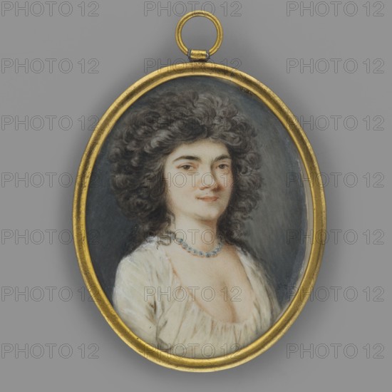 Portrait of a Woman, Taubert, Gustav Friedrich Amalius 1755–1839 painter; jewelry; women; portraits en three-quarters; Polish miniatures; portraits of women; 3/4 bust right. Dark brown hair in curls falling over the shoulders. Dark eyes; white, deeply bustled dress. Necklace with greenish-blue stones. Background: dark gray, slightly lighter on the right. Binding: narrow oval frame made of gilded bronze, convex glass edges French style. 1797, Warsaw; miniature; height 5.1 cm, width 4.0 cm, An oval gold frame pendant containing a painted portrait of a person with dark curly hair, pale skin, and a slight smile, wearing a white, low-cut garment and a blue beaded necklace, set against a dark bluish-gray background; the outer area around the pendant is a medium gray.