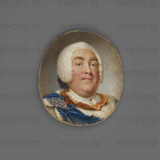 Augustus III Wettin 1696–1765 in coronation robes and armor; painted by Pietro Rotari 1707–1762 attributed; portrait miniature, 1750; three-quarter right, shoulder-length; low wig in catogan, white shirt and jabot; chain of the Order of the Golden Fleece at the neck; coronation mantle trimmed with ermine; background: fragment of grey-olive sky, brightened on the right; no frame; height 2.5 cm, width 2.3 cm., A painted oval miniature of a man with pale skin and a white powdered wig, shown from the shoulders up against a muted gray background; his face shows pinkish cheeks and lips with light blue eyes and dark eyebrows, and he wears clothing with blue and white fabric, a golden brown collar trim, and a small area of jeweled or beaded decoration in silver tones.