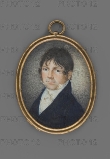 Michal Bulharyn, member of parliament, scribe of the Wolkowysk lands, unknown role classification of the artist, painter author; portrait en three-quarters of a man nobility, male portrait; Polish miniature, 1810, Poland Lithuania?. Bust facing left. Dark hair with a fringe falling over the forehead à la Tytus, dark blue eyes. Shirt collar, cravat, and waistcoat white, navy blue frock coat. Background brownish-gray, stippled, brightened on the right. Binding with gilded brass rim, half-round. On the reverse of the binding inscription: “Mich. Bulharyn / 1785 + 1842.” Miniature, height 5.1 cm, width 4.1 cm., An oval pendant with a gold-toned frame contains a small painted portrait of a man with dark brown hair and sideburns wearing a dark blue coat and a light-colored cravat; the background around the figure is a mottled gray, and the overall visible colors include gold, dark blue, brown, light beige, and gray.