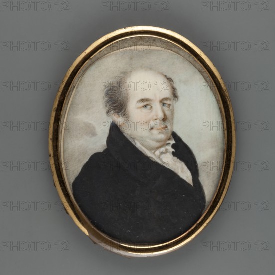Jedrzej Sniadecki 1768–1838, famous professor of chemistry and medicine, portrait, unknown artist. Half-length three-quarter figure facing right. Dark, graying hair, blue eyes. White shirt collar, cravat and waistcoat, black coat. Background sandy-bluish with gray clouds. Oval brass frame smooth half-cylinder with convex glass. 1815. Miniature; height 6.7 cm, width 5.5 cm., An oval portrait miniature set in a thin gold frame shows a seated man with pale skin and thinning hair that is gray and brown, wearing a dark black coat over a light cream-colored shirt with ruffled collar; his face has blue eyes and a neutral expression, and the background is a soft, muted blend of gray and off-white tones.