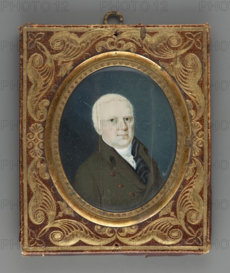 Baron Schwerin, Verner Gottlob von Schwerin; Martina's husband?; unknown painter; Thomann fl. 1815 copy from Thomann; portrait en trois-quarts; male portrait of nobility; foreign miniature; amateur artist; ; dated 1815; miniature; height 6.0 cm, width 4.9 cm., A small framed oval portrait of a middle-aged person with pale skin and light-colored hair set against a dark bluish-gray background, the subject wearing a dark olive green coat and a white neckcloth with a dark scarf visible; the portrait is encased in a round gilded bezel with decorative engraving, mounted in a rectangular case covered in reddish-brown material adorned with ornate gold scrollwork and leaf motifs, the case showing some wear along the edges and a small metal hanging loop at the top.