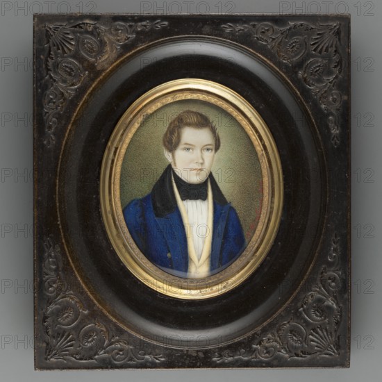 Michal Wankowicz born 1808 of the Lis coat of arms, son of Kasper and Eleonora née Makowiecka. En face portrait of a man — bust slightly right. Blond hair, grey-blue eyes. White shirt, black tie, yellow vest, light sapphire tailcoat with black collar. Background olive, stippled, brightened on the right around the face. Biedermeier style. Inscription on recto: A. Fernkorn 1836. Inscription on reverse: Michal Wankowicz / 28 years old / Father of Józia and Misia / born 1832 born 1834 / March 27, 1836. Miniature, height 7.4 cm, width 6.0 cm. Oval frame of gilded bronze with a palmette motif set in a mass imitating wood, the whole in a rectangle with semi-convex ornaments in the corners. Artists attributed: Fernkorn, Anton Dominik von 1813–1878, sculptor possibly; Fernkorn A. fl. 1836, lithographer. Subjects: men, male portrait; Polish costume; Vilnius., A painted oval portrait of a young person with light skin and brown hair set within a round gold-colored inner frame and a larger dark mol...
