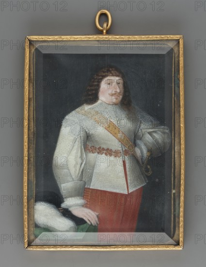 Prince Wladyslaw Vasa, in the future Wladyslaw IV 1595–1632, unknown artist, three-quarter-length portrait, copy, male ruler, foreign miniature, Knee-length, 3/4 to the right, dark hair curled to the shoulders, blond mustache and Spanish-style beard, wide white collar of openwork lace, silver caftan with slits on the sleeves, at the waist a belt of quadruple red bows, pantaloons of the same color, at the left side a sword with a gold hilt suspended on a narrow gold ribbon. The right hand rests on a table covered with green fabric, on which rests a black hat with a white ostrich feather. The left arm is bent at the elbow, with the hand on the hip. Background: dark. Frame: narrow gilded bronze frame chiseled with plant ornaments. Date: 1630. Miniature, height 9.7 cm, width 6.9 cm., A framed portrait of a man shown from the waist up wearing ornate clothing, with a dark background and a gold-colored rectangular frame and loop at the top. The man has shoulder-length dark brown hair and a mu...