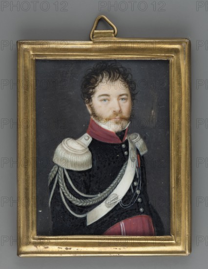 Portrait future general Ignacy Pradzynski 1792–1850 in the uniform of a colonel of the troops of the Duchy of Warsaw, unknown artist; half-length, three-quarter figure facing right, face almost straight. Dark hair, sideburns, blond mustache, blue eyes. White shirt collar, black scarf, dark navy uniform with magenta collar, epaulettes, aiguillettes, cartridge belt with silver decorations, silver buttons, magenta trousers, white or silver braid at the trouser lapel. Background: dark gray. Rectangular bronze-sheet frame on the reverse; inside the frame: inscription Pradzynski / General / Chief of Staff. Miniature; height 7.6 cm, width 6.2 cm; dated 1810, Poland., A framed portrait of a man shown from the chest up wearing a dark uniform with a red collar and red trim, pale shoulder epaulettes with braided cords, and a light-colored diagonal sash; he has fair skin, blue eyes, curly dark brown hair, sideburns and a mustache, and a neutral expression, set against a dark background and enclose...