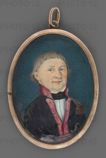 a Portrait of a young nobleman in the uniform of a lieutenant of the National Guard. Bust, slightly right. Short blond hair. White collar, black cravat, navy blue uniform with one epaulet, amaranth collar and lapels, amaranth and silver belt, a sabre hilt visible at the left side. Background stippled, dark blue-green. Smooth copper-bronze rim. b Portrait of the same man at an older age in the uniform of the troops of the Kingdom of Poland. Painted photo, most probably showing the same person, on the reverse a photograph of a man in a military uniform; circa 1840–1850. Miniature, height 5.2 cm, width 4.1 cm. Unknown artist; portraits en trois-quarts; male nobility; Polish miniatures; kontusz coats; military men., An oval pendant with a metallic gold-toned frame and loop contains a painted miniature portrait of a person set against a deep teal-blue background; the person has light skin, short light brown hair with bangs, and a neutral expression, wearing a dark coat with a pinkish-red tr...